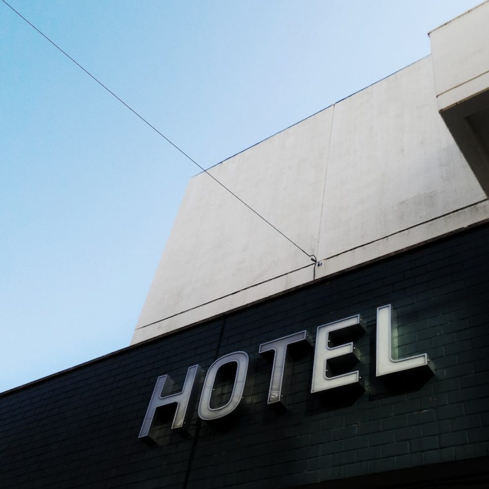 black and white concrete hotel building under a calm blue sky